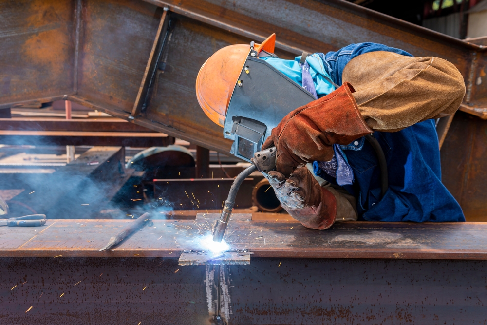 Welder welding a steel structure using FCAW equipment